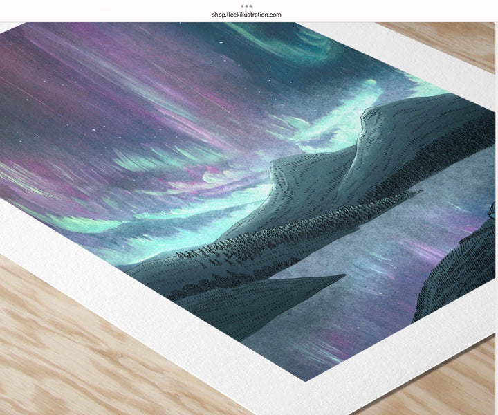 Art print of a mountain landscape with colorful sky on a wooden surface