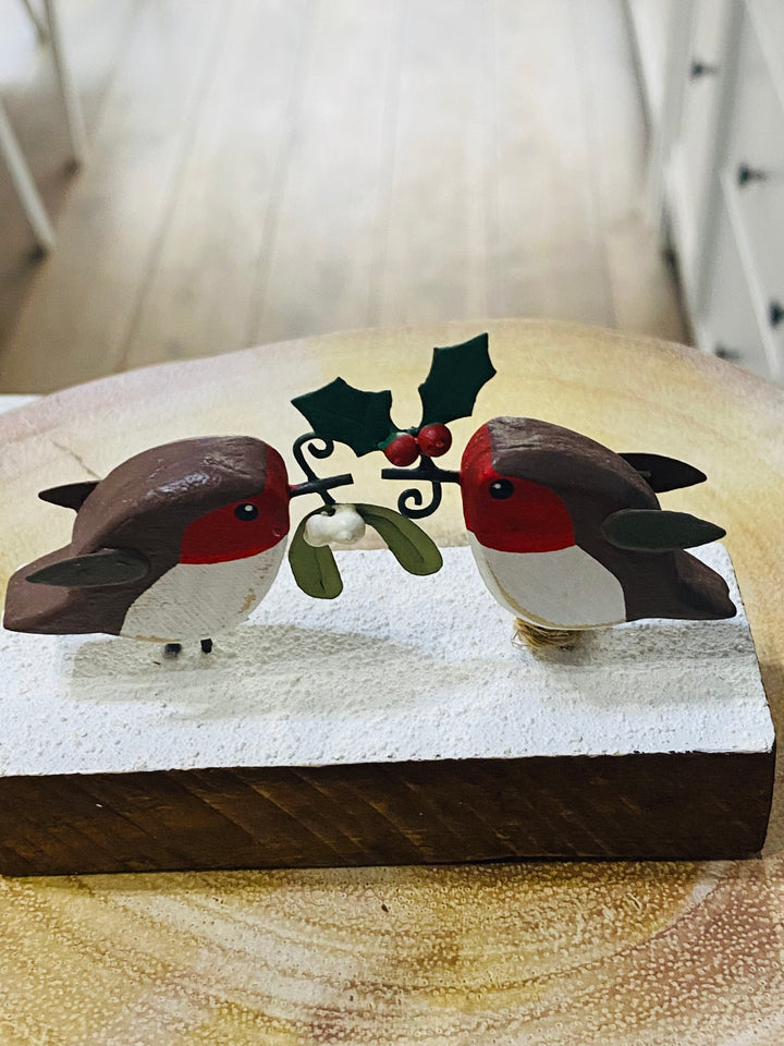 Wooden ornament with two birds and holly on a wooden base