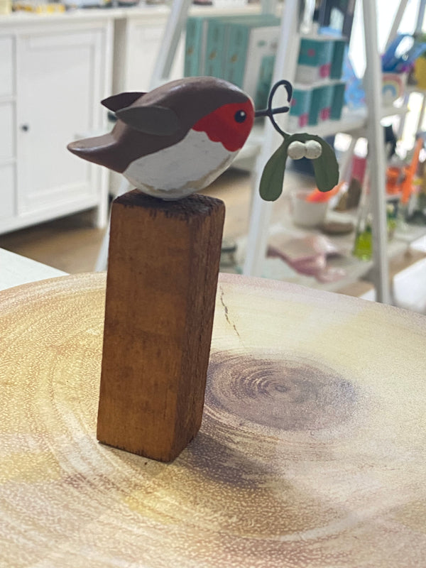 Decorative christmas robin
 ornament hanging on a wooden block 