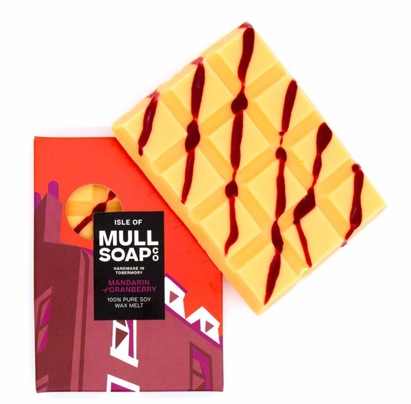 Yellow wax melt with red drizzle pattern on a branded packaging