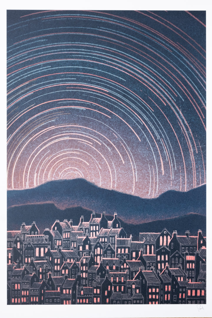 A serene image of Edinburgh old town with rolling hills behind it with star trails circling the sky